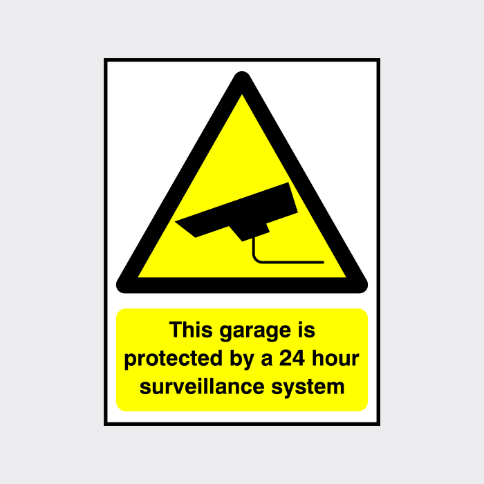 This garage is protected by a 24 hour surveillance system sign